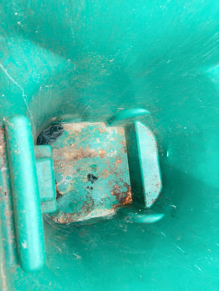 Rusted metal underwater object with turquoise floats, photographed from above in clear turquoise water